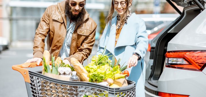 Man and woman with fresh food on the supermarket parking